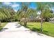 Brick home with solar panels, lined with majestic palm trees, sits at the end of a private driveway at 519 Donaldson Dr, Debary, FL 32713