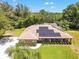 Aerial view of a lovely brick home with solar panels, surrounded by lush greenery and a spacious, well-maintained lawn at 519 Donaldson Dr, Debary, FL 32713