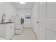 All white laundry room with sink, front load washer and dryer, tile floor, and white walls at 519 Donaldson Dr, Debary, FL 32713