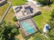 Aerial view of a kidney-shaped pool with a screened-in enclosure, solar panels, plus ample backyard space for entertaining at 519 Donaldson Dr, Debary, FL 32713
