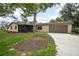 Charming single-story home with well-maintained lawn, a large tree, and a driveway leading to an attached garage at 5402 Turton Ln, Port Orange, FL 32127