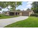 Charming single-story home with well-maintained lawn, a large tree, and a driveway leading to an attached garage at 5402 Turton Ln, Port Orange, FL 32127
