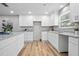 Bright kitchen featuring white cabinets, granite countertops, modern lighting, and stainless steel appliances at 5402 Turton Ln, Port Orange, FL 32127