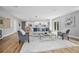 Open-concept living area with hardwood floors, contemporary furniture, and seamless transition to dining space at 5402 Turton Ln, Port Orange, FL 32127