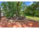The backyard features a brick-paved patio with a sitting area surrounded by lush landscaping at 552 Hamlet Dr, Port Orange, FL 32127