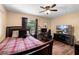 Comfortable bedroom with wood floors, a ceiling fan, and a dedicated computer gaming setup at 552 Hamlet Dr, Port Orange, FL 32127