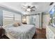 Comfortable bedroom with a queen-size bed, a ceiling fan, and a sliding barn door at 552 Hamlet Dr, Port Orange, FL 32127