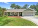 Charming single-story home with a well-manicured lawn, inviting curb appeal and a screen enclosed garage at 552 Hamlet Dr, Port Orange, FL 32127