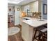 Charming kitchen featuring light cabinets, modern backsplash, a breakfast bar, and wood-look flooring at 552 Hamlet Dr, Port Orange, FL 32127