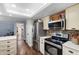 Updated kitchen with stainless appliances, light cabinets, stone backsplash, and wood flooring at 552 Hamlet Dr, Port Orange, FL 32127