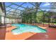 Inviting pool with a screened enclosure surrounded by a patio for outdoor relaxation at 552 Hamlet Dr, Port Orange, FL 32127