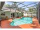 Sparkling screened in pool with an expansive deck, loungers and a dining table at 552 Hamlet Dr, Port Orange, FL 32127
