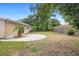 Backyard with lush greenery, wood fence, and concrete patio; perfect for outdoor entertaining at 5825 Forest Grove Blvd, Orlando, FL 32808