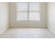 This bright bedroom features natural light and tiled floors at 5825 Forest Grove Blvd, Orlando, FL 32808