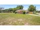 This single-story home has a large front yard, landscaping, and covered parking on the side at 5825 Forest Grove Blvd, Orlando, FL 32808