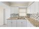 Bright kitchen features granite countertops, tile backsplash, stainless steel sink, and white cabinets at 5825 Forest Grove Blvd, Orlando, FL 32808