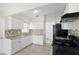 Updated kitchen with white cabinetry, tile backsplash, and modern black appliances at 5825 Forest Grove Blvd, Orlando, FL 32808