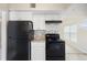 Modern kitchen with white cabinetry, granite countertops, and sleek black appliances at 5825 Forest Grove Blvd, Orlando, FL 32808