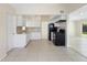 Open kitchen layout with white cabinets, black appliances, and tiled flooring at 5825 Forest Grove Blvd, Orlando, FL 32808