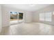 Bright living room with sliding glass door, neutral walls, and tile flooring at 5825 Forest Grove Blvd, Orlando, FL 32808