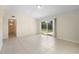 Open concept living room featuring neutral paint, tile floors, and a glass sliding door to the yard at 5825 Forest Grove Blvd, Orlando, FL 32808