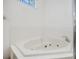 Bathroom featuring a relaxing white tub with jets and tiled backdrop for a spa-like experience at 6083 Sabal Hammock Cir, Port Orange, FL 32128