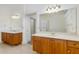 Dual vanities with wood cabinets, white countertops, and bright lighting offering plenty of space at 6083 Sabal Hammock Cir, Port Orange, FL 32128