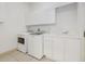 A laundry room equipped with a washer, dryer, sink, white cabinets for efficient organization at 6083 Sabal Hammock Cir, Port Orange, FL 32128