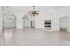 Open-plan living room with tile floor, arches, a fireplace, and chandelier-lit foyer with double doors at 6083 Sabal Hammock Cir, Port Orange, FL 32128