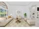 Staged living room featuring a large arched window, neutral carpet, and columned archway to attached area at 6083 Sabal Hammock Cir, Port Orange, FL 32128