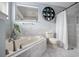 Clean bathroom showcasing a tub, tiled walls, a decorative shelf, and a window for natural light at 613 John Thomas Ave, Deland, FL 32724