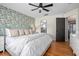 Well-lit bedroom featuring a ceiling fan, hardwood floors, statement wall paper, and ensuite access at 613 John Thomas Ave, Deland, FL 32724