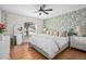 Bright bedroom featuring a ceiling fan, hardwood floors, statement wall paper, and a serene view at 613 John Thomas Ave, Deland, FL 32724