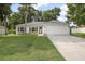Charming single-story home featuring a manicured lawn, two car garage and mature trees at 613 John Thomas Ave, Deland, FL 32724