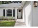 Close up of front door with wreath and black hardware, framed by plants and a clean, bright facade at 613 John Thomas Ave, Deland, FL 32724