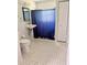 Bright bathroom with white tile, sink, toilet, and shower with blue curtain at 632 W Hubbard Ave, Deland, FL 32720