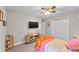 This carpeted bedroom has a ceiling fan, closet, television, and decorative shelf at 64 Ravenwood Ct, Ormond Beach, FL 32174