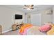 This carpeted bedroom has a ceiling fan, closet, television, and decorative shelf at 64 Ravenwood Ct, Ormond Beach, FL 32174