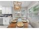Cozy dining area features a stylish table setting, modern lighting, and views of the backyard through bright windows at 64 Ravenwood Ct, Ormond Beach, FL 32174