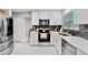 Modern kitchen boasts white cabinetry, stainless steel appliances, and sleek countertops with mosaic tile backsplash at 64 Ravenwood Ct, Ormond Beach, FL 32174