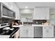 Bright kitchen features white cabinets, stainless steel appliances and modern countertops at 64 Ravenwood Ct, Ormond Beach, FL 32174