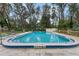 This in-ground community swimming pool is surrounded by fencing and lounge chairs at 64 Ravenwood Ct, Ormond Beach, FL 32174