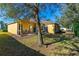 View of the back of the house, which features a small patio and well-manicured landscaping at 727 Grape Ivy Ln, New Smyrna Beach, FL 32168