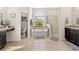 Bathroom featuring a soaking tub, glass enclosed shower, dual sink vanity, and natural light at 727 Grape Ivy Ln, New Smyrna Beach, FL 32168
