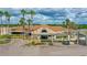 An image of the Sugar Mill Country Club's exterior showing palm trees, landscaping, and a golf cart at 727 Grape Ivy Ln, New Smyrna Beach, FL 32168