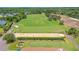 This aerial shows the putting green and part of the golf course at Sugar Mill Country Club at 727 Grape Ivy Ln, New Smyrna Beach, FL 32168