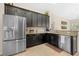 Modern kitchen with stainless steel refrigerator and appliances, dark cabinets and tile floors at 727 Grape Ivy Ln, New Smyrna Beach, FL 32168
