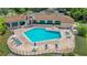 Aerial view of a community pool with lounge chairs and umbrellas, next to a building with large windows at 727 Grape Ivy Ln, New Smyrna Beach, FL 32168
