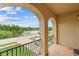View from the tiled balcony featuring a lake and lush landscaping beyond the wrought iron railing at 762 Onyx Pkwy, Deland, FL 32724