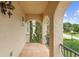 Tiled balcony with stucco arches offering a view of the landscaped neighborhood at 762 Onyx Pkwy, Deland, FL 32724